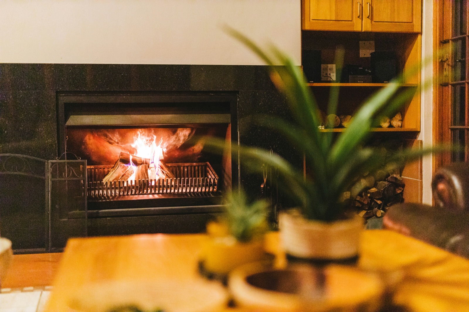 A warm fireplace interior with golden tungsten light, contemplative and inviting.